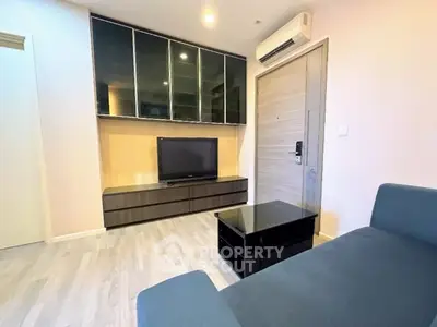 Modern living room with sleek furniture and wall-mounted TV in a stylish apartment.