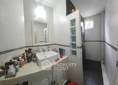 Spacious bathroom with modern fixtures and ample storage space.