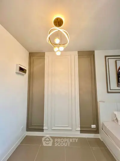 Modern bedroom with elegant wall paneling and stylish ceiling light fixture.