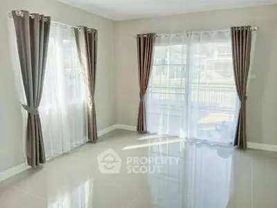 Bright and spacious empty room with large windows and elegant curtains