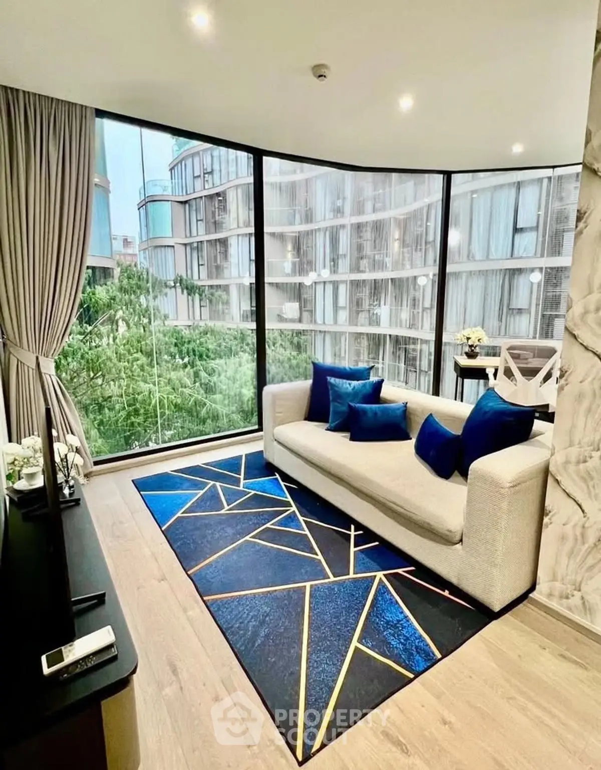Modern living room with floor-to-ceiling windows and stylish geometric rug.