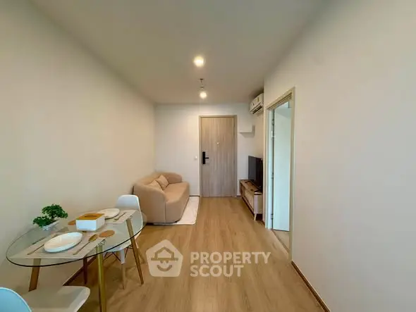 Modern living room with cozy sofa and dining area in open layout apartment.