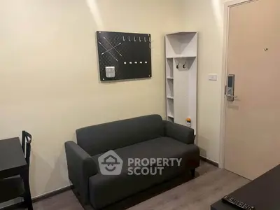 Cozy living room with modern sofa and wall hooks, perfect for urban living.