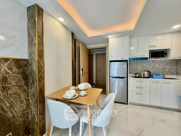 Modern kitchen with sleek appliances and stylish dining area in a contemporary apartment.
