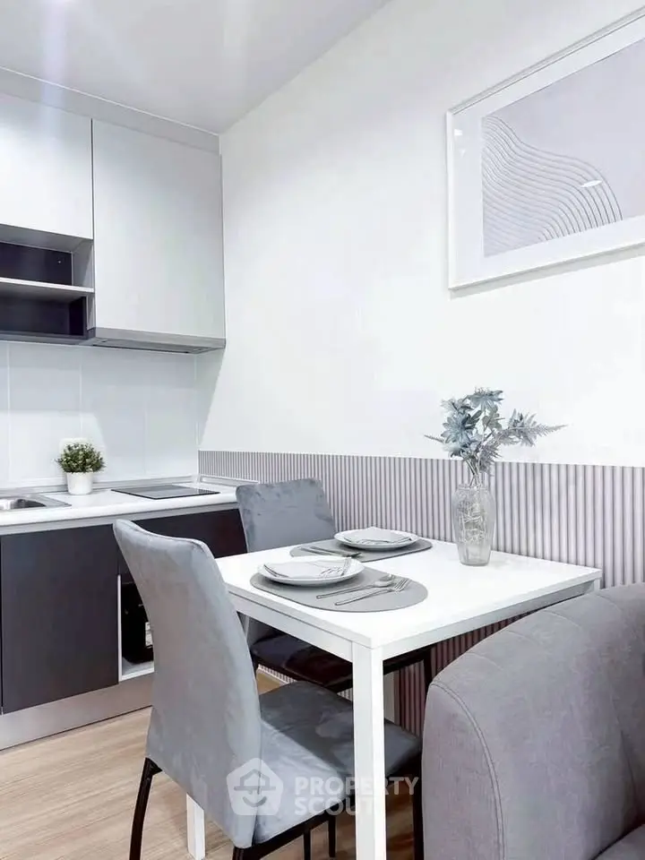 Modern kitchen with sleek design and cozy dining area in a stylish apartment.