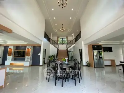 Spacious luxury living room with high ceilings and elegant staircase