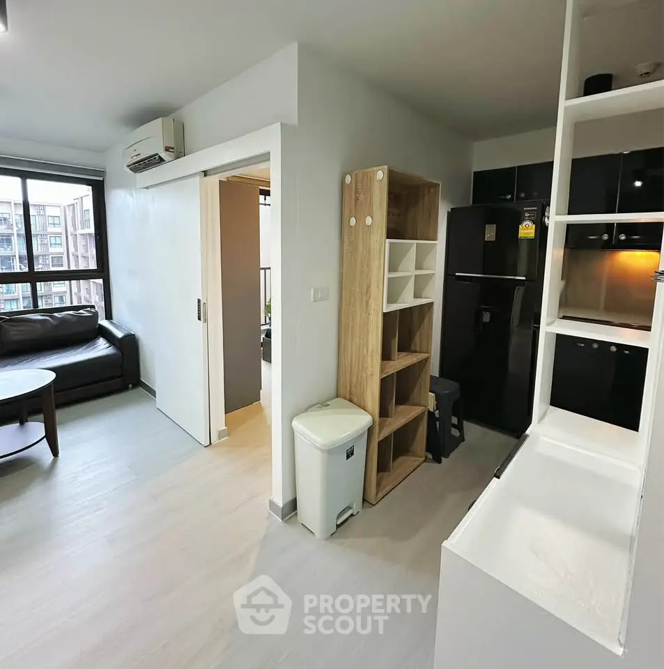 Modern apartment interior with open layout, featuring sleek kitchen and cozy living area.