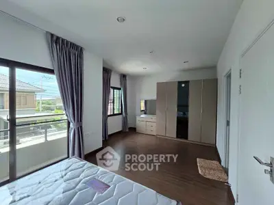 Spacious bedroom with large windows and modern wardrobe in a bright home.