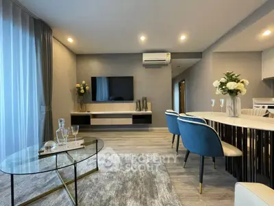 Modern living room with elegant decor, featuring a sleek TV setup and stylish dining area.