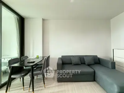 Modern living room with sleek gray sofa and elegant dining table, perfect for urban living.
