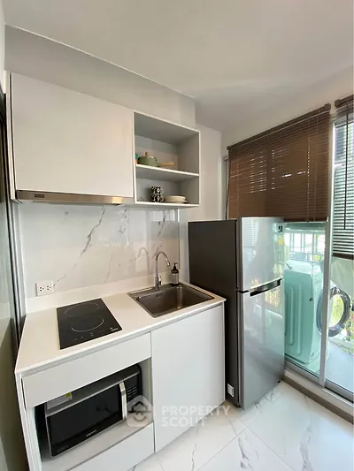 Modern compact kitchen with sleek appliances and natural light