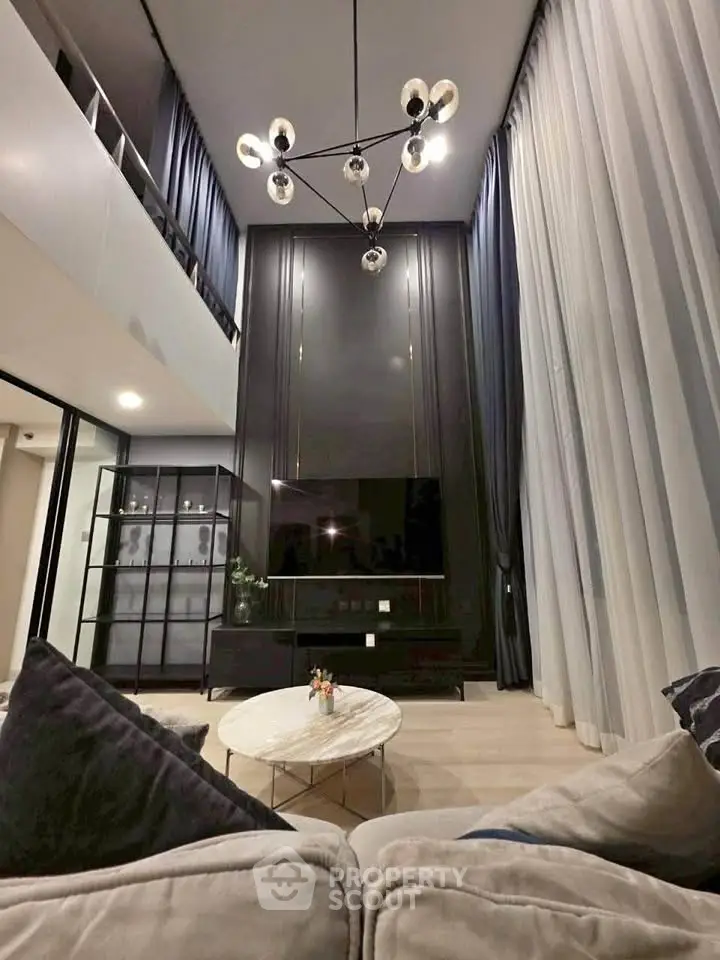 Luxurious modern living room with high ceilings and elegant chandelier