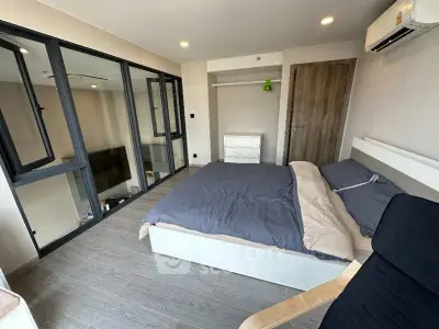 Modern bedroom with large windows and sleek design in a contemporary apartment.