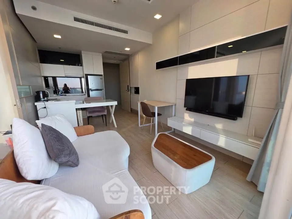 Modern living room with sleek furniture and open kitchen layout in a stylish apartment.
