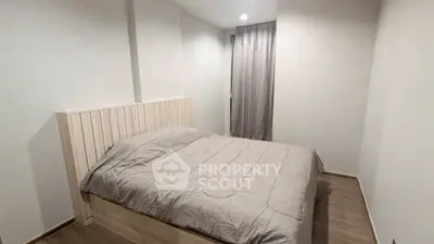 Cozy minimalist bedroom with wooden flooring and neutral tones.