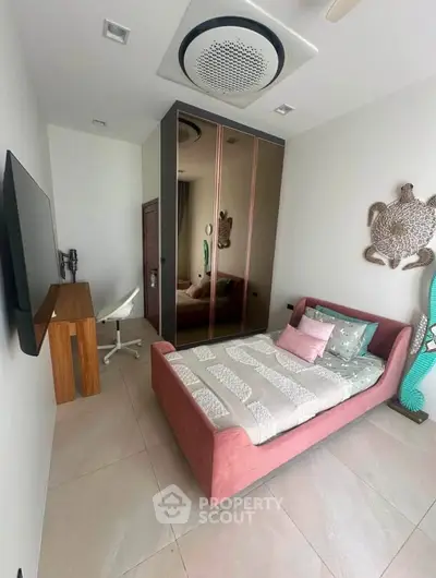 Modern bedroom with stylish decor and mirrored wardrobe in a cozy apartment.