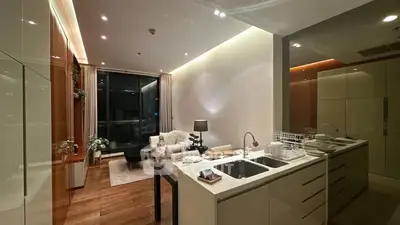 Modern open-layout kitchen and living room with sleek design and ambient lighting.