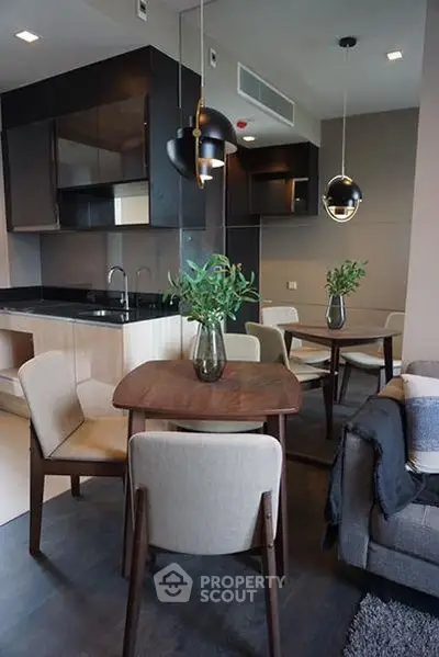 Modern open-layout kitchen and dining area with stylish lighting and cozy seating.