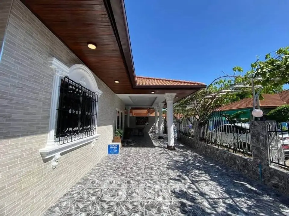 Charming exterior view of a modern home with tiled pathway and elegant columns.