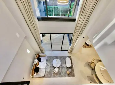 Stunning modern living room with high ceilings and elegant decor, featuring a spacious open layout and large windows.