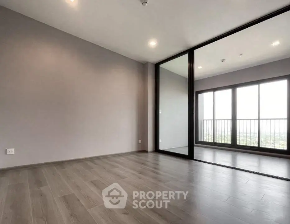 Spacious modern living room with large windows and wooden flooring