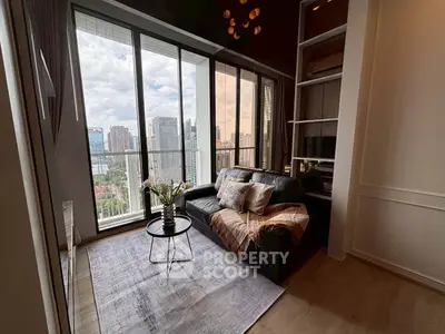 Modern living room with floor-to-ceiling windows and city view, featuring cozy seating and stylish decor.