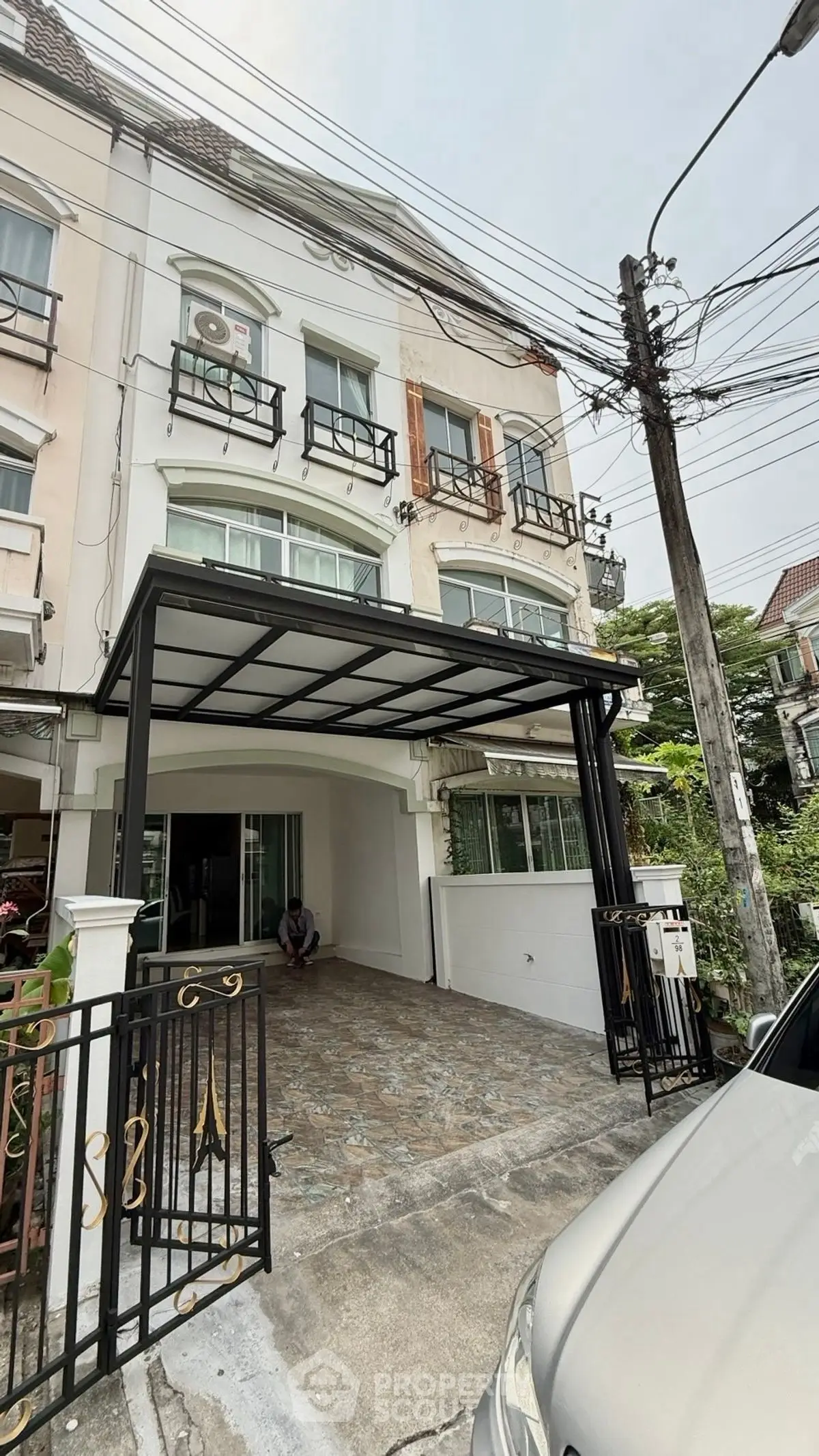 Charming three-story townhouse with covered parking and elegant facade in a serene neighborhood.