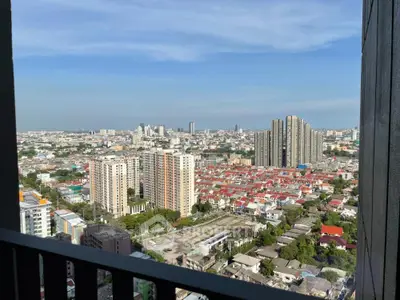 Stunning cityscape view from a high-rise balcony showcasing urban skyline and residential areas.