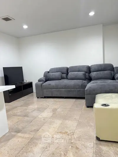 Spacious living room with modern gray sofa and sleek TV setup