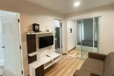 Modern living room with sleek TV unit and cozy sofa, adjacent to a bedroom with sliding glass doors.