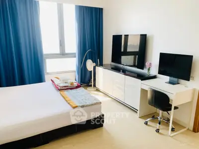 Modern bedroom with large window, stylish furniture, and workspace setup.