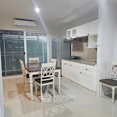 Charming kitchen with dining area, featuring white cabinetry and modern appliances, perfect for family gatherings.