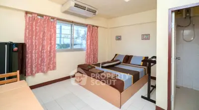 Cozy bedroom with air conditioning and en-suite bathroom in a well-lit apartment.