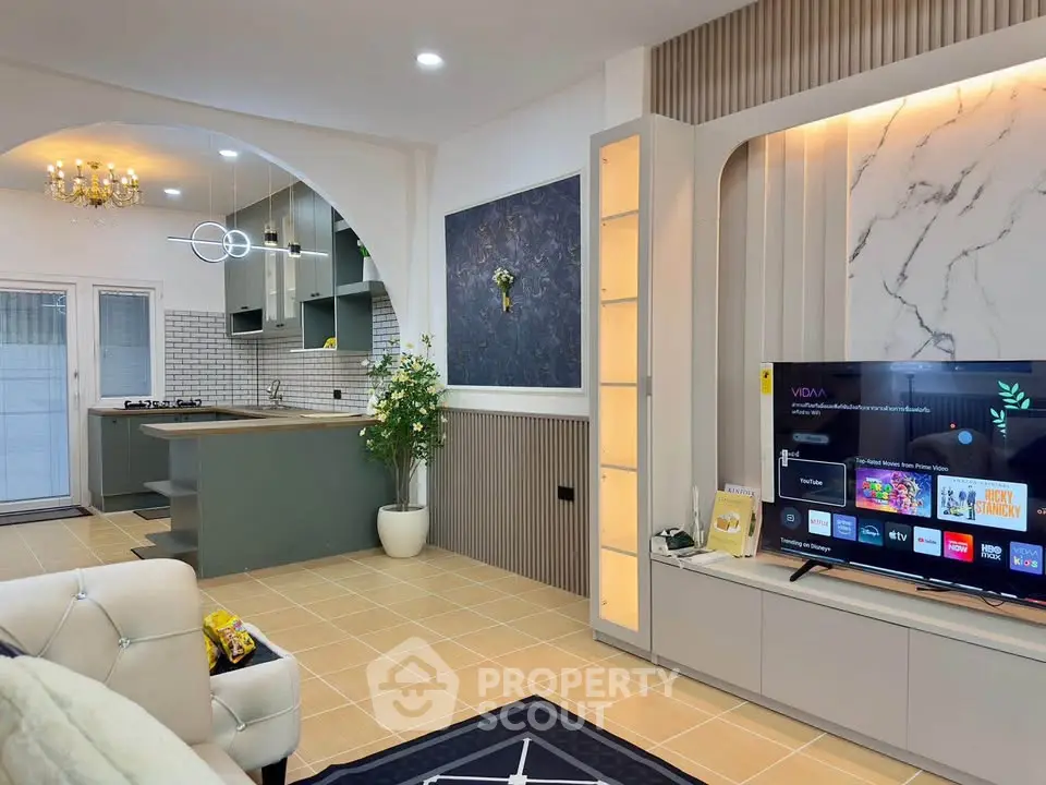Modern open-plan living room with stylish kitchen, featuring elegant decor and contemporary furnishings.