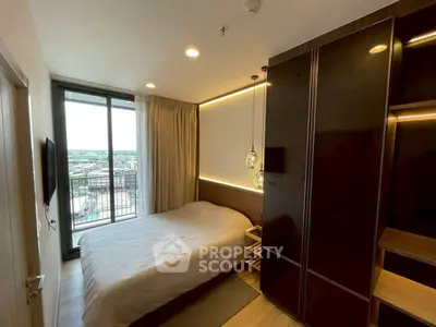 Modern bedroom with balcony view, sleek design and ample natural light.