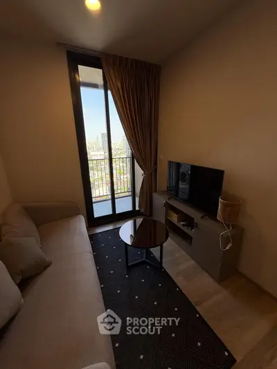 Cozy living room with balcony view, modern sofa, and TV setup.