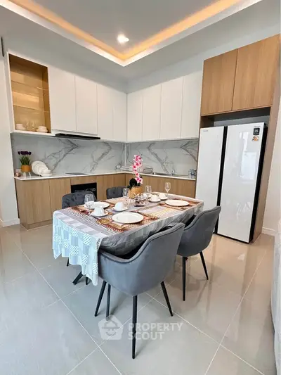 Modern kitchen with elegant dining setup and sleek appliances