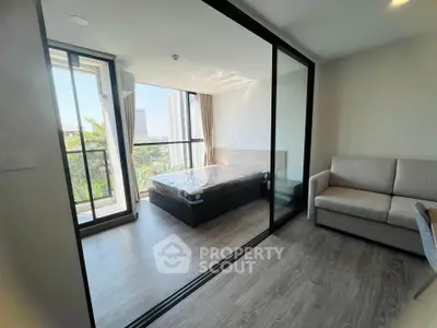 Modern bedroom with glass partition and balcony view in a stylish apartment
