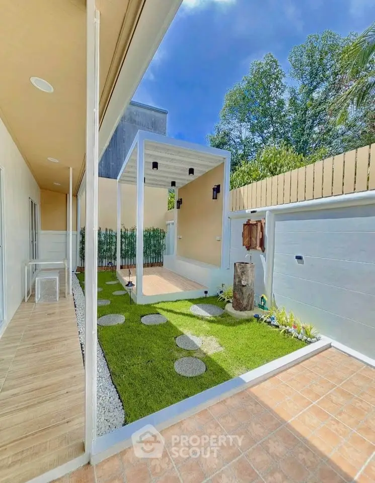 Modern outdoor garden with stepping stones and covered patio area, perfect for relaxation and entertainment.