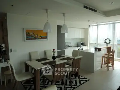 Modern open-layout kitchen and dining area with natural light and stylish decor.