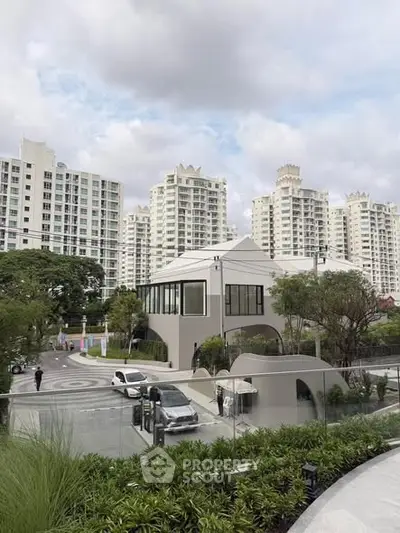 Modern residential complex with lush greenery and contemporary architecture.