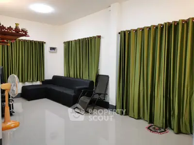 Spacious living room with green curtains and modern black furniture