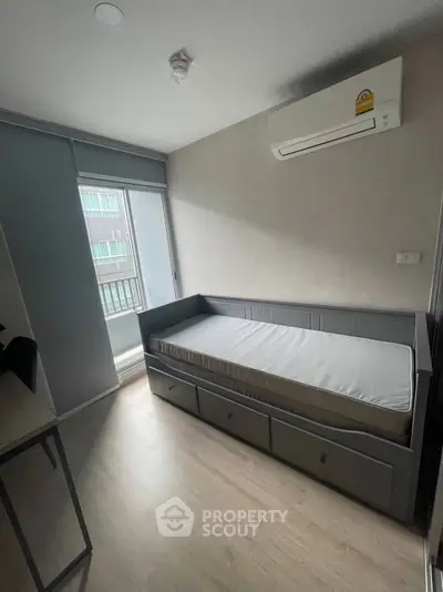 Compact bedroom with single bed and air conditioning in modern apartment.