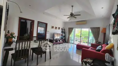 Spacious living room with modern decor and large windows offering garden view
