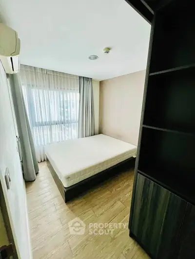 Cozy bedroom with natural light and modern furnishings in a stylish apartment.