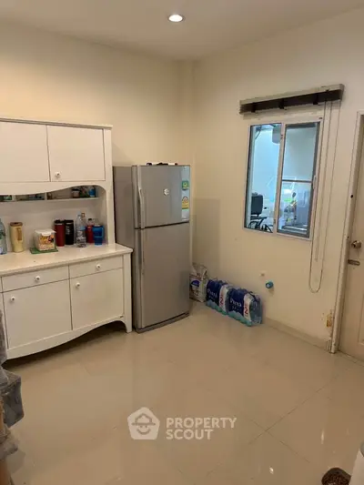 Spacious kitchen with modern fridge and ample storage in a bright, clean setting.