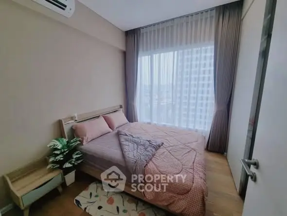 Cozy bedroom with large window and modern decor in urban apartment.