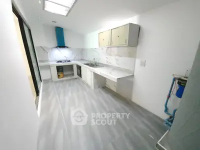 Modern kitchen with sleek design, marble backsplash, and gas stove in a spacious layout.