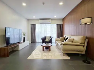 Modern living room with sleek furniture and large TV, featuring a cozy ambiance.