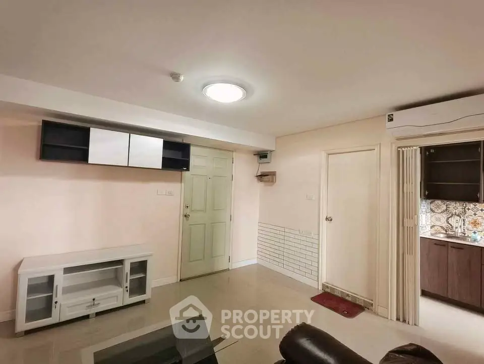 Spacious living room with modern furniture and open kitchen layout in a cozy apartment.